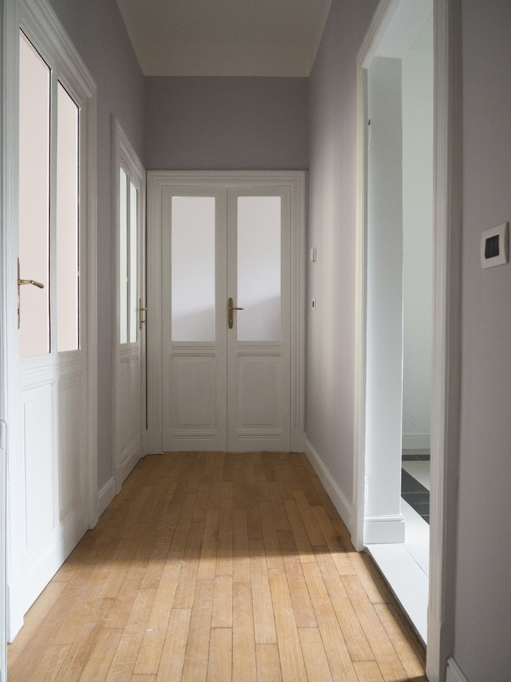 This is an example of a mid-sized midcentury hallway in Other with grey walls, painted wood floors and beige floor.