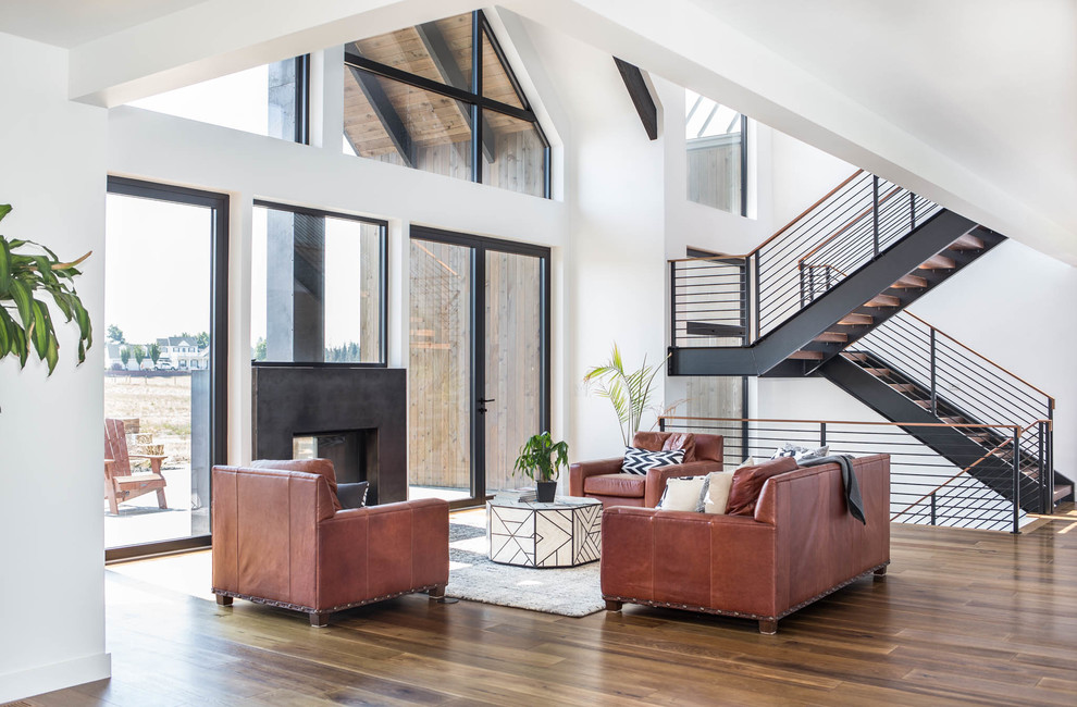 Inspiration for a large contemporary open concept living room in Seattle with medium hardwood floors, white walls, a two-sided fireplace, a concrete fireplace surround, no tv and brown floor.