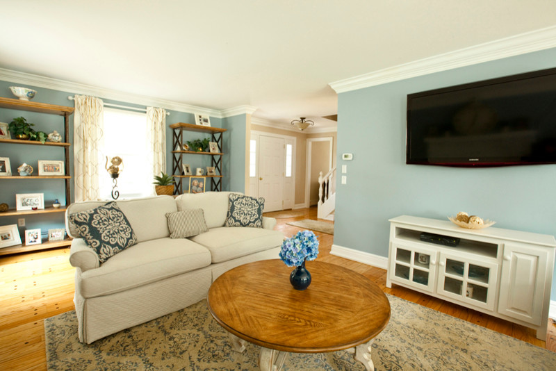 This is an example of a mid-sized transitional formal enclosed living room in Bridgeport with blue walls, medium hardwood floors, a standard fireplace and a wood fireplace surround.