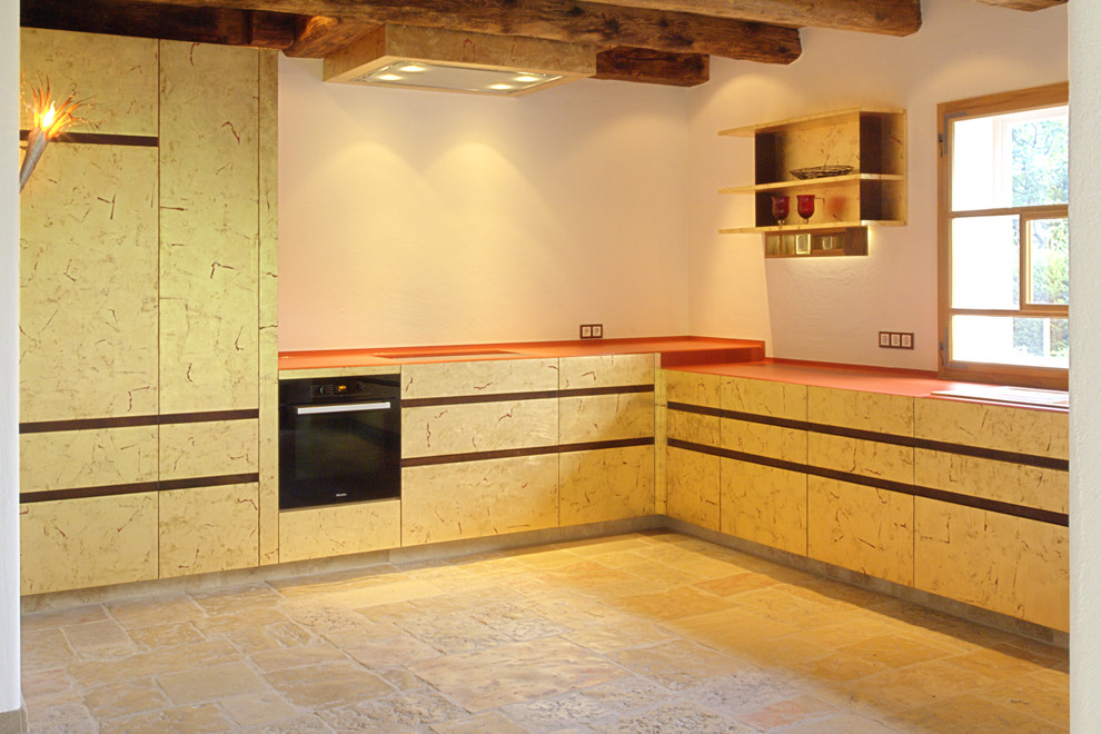 Wohnküche ohne Insel in L-Form mit Waschbecken, Kassettenfronten, beigen Schränken, Arbeitsplatte aus Holz, Küchenrückwand in Weiß, Rückwand aus Stein, Küchengeräten aus Edelstahl, Backsteinboden, beigem Boden und oranger Arbeitsplatte