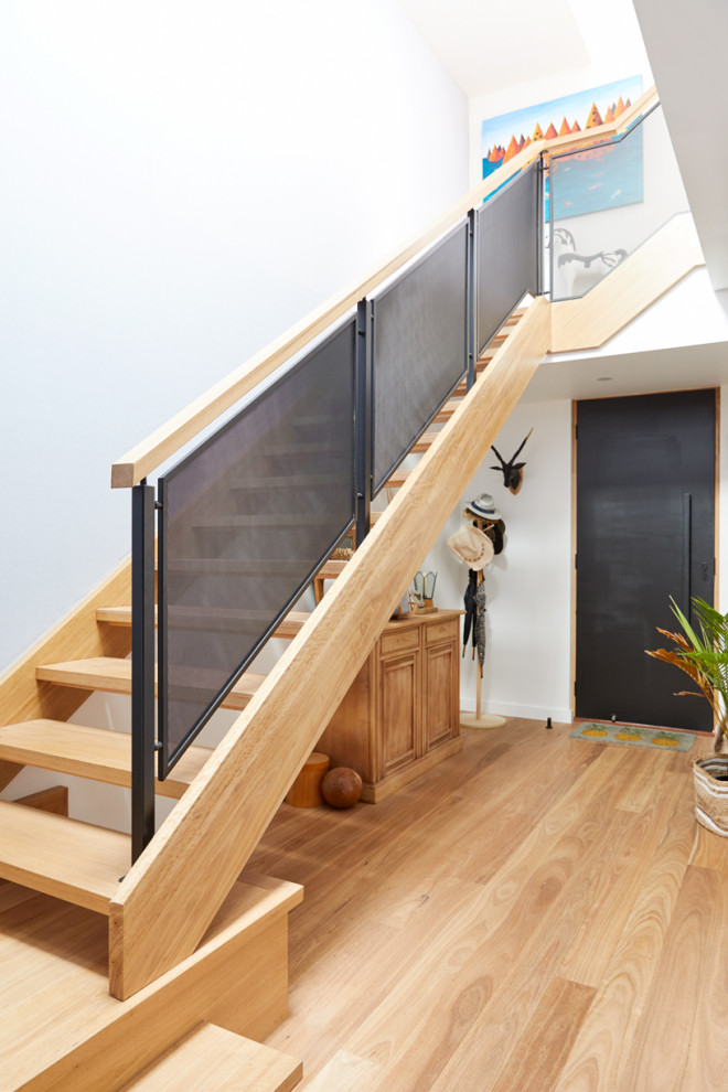 Photo of a mid-sized contemporary wood l-shaped staircase in Melbourne with open risers and wood railing.