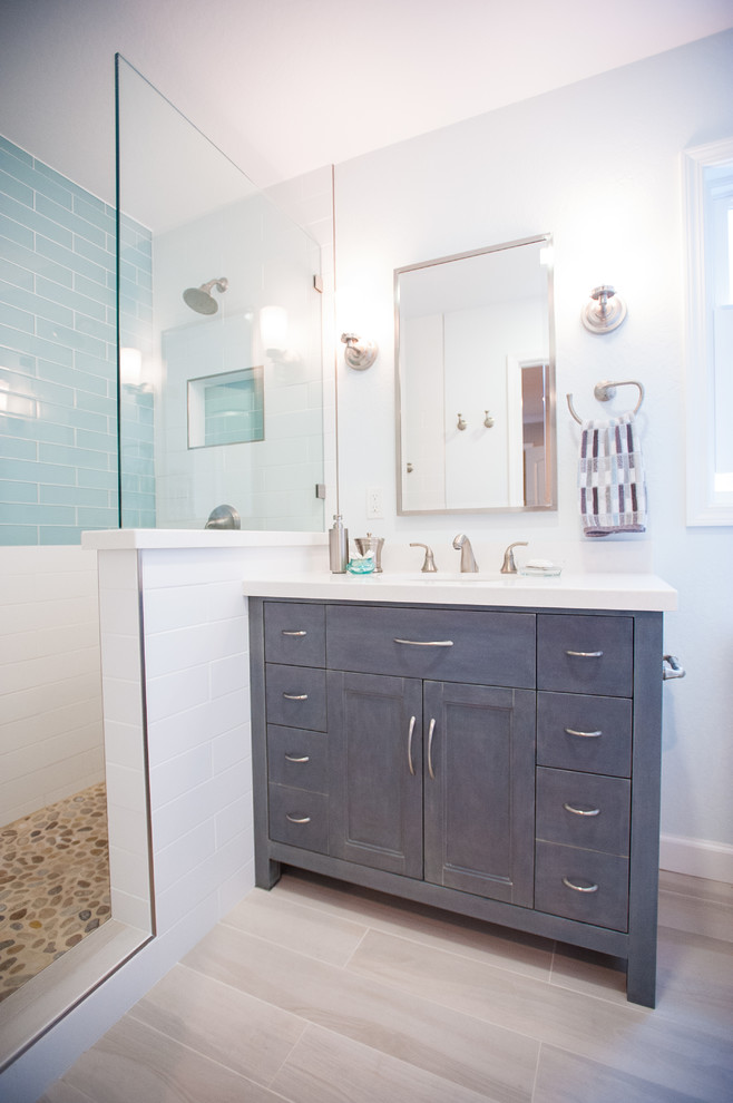 This is an example of a transitional master bathroom in San Francisco with beaded inset cabinets, grey cabinets, an alcove shower, blue tile, white tile, subway tile and pebble tile floors.