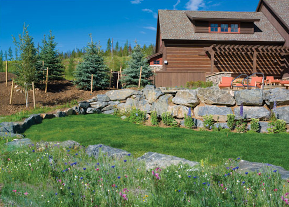 Design ideas for a mid-sized rustic full sun backyard stone landscaping in Denver for summer.