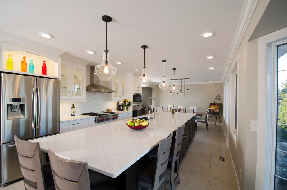 Eat-in kitchen - transitional galley limestone floor eat-in kitchen idea with an undermount sink, white cabinets, quartz countertops, white backsplash, ceramic backsplash, stainless steel appliances and an island