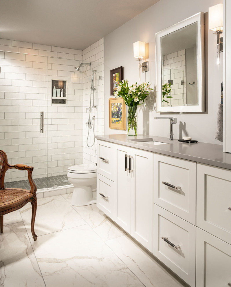 Example of a mid-sized transitional master white tile and subway tile porcelain tile, white floor and single-sink alcove shower design with white cabinets, gray walls, an undermount sink, quartzite countertops, a hinged shower door, gray countertops and a built-in vanity
