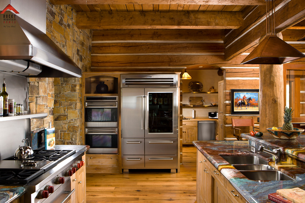 Example of a mid-sized mountain style l-shaped light wood floor kitchen pantry design with light wood cabinets, granite countertops, stainless steel appliances and an island