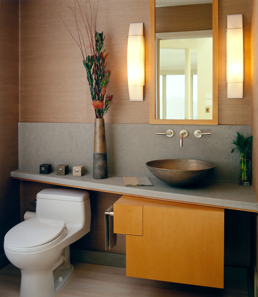 Design ideas for a small contemporary powder room in San Francisco with a vessel sink, flat-panel cabinets, a one-piece toilet, beige walls, travertine floors and medium wood cabinets.