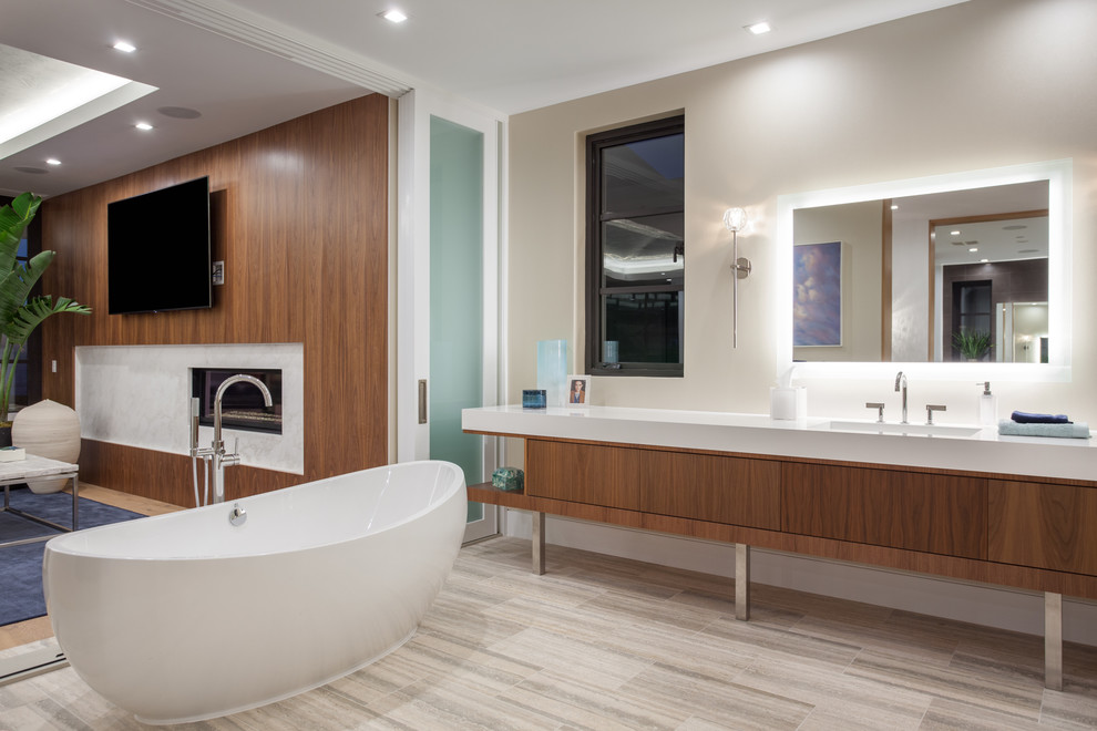 Expansive contemporary master bathroom in Orange County with flat-panel cabinets, medium wood cabinets, a freestanding tub, white walls, an integrated sink, engineered quartz benchtops, multi-coloured floor and white benchtops.