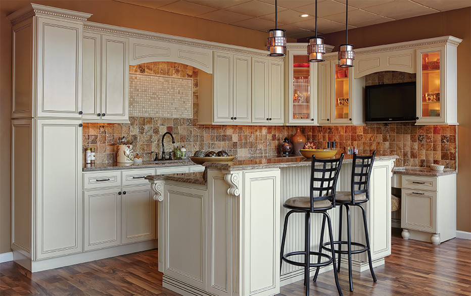Inspiration for a transitional medium tone wood floor eat-in kitchen remodel in Philadelphia with a drop-in sink, raised-panel cabinets, white cabinets, granite countertops, brown backsplash, stone tile backsplash and stainless steel appliances