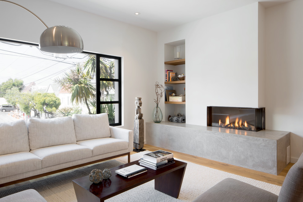 This is an example of a mid-sized contemporary enclosed living room in San Francisco with white walls, light hardwood floors, a ribbon fireplace and beige floor.