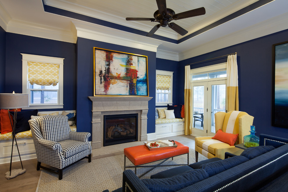 Example of a transitional open concept light wood floor living room design with a standard fireplace, a stone fireplace and blue walls