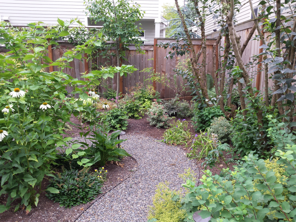 Photo of a small contemporary backyard partial sun garden for summer in Portland with a garden path, gravel and a wood fence.