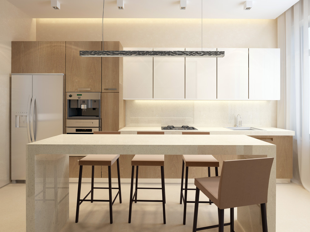 Inspiration for a mid-sized modern single-wall kitchen in Minneapolis with a drop-in sink, flat-panel cabinets, white cabinets, quartz benchtops, beige splashback, stone slab splashback, stainless steel appliances, with island and beige floor.
