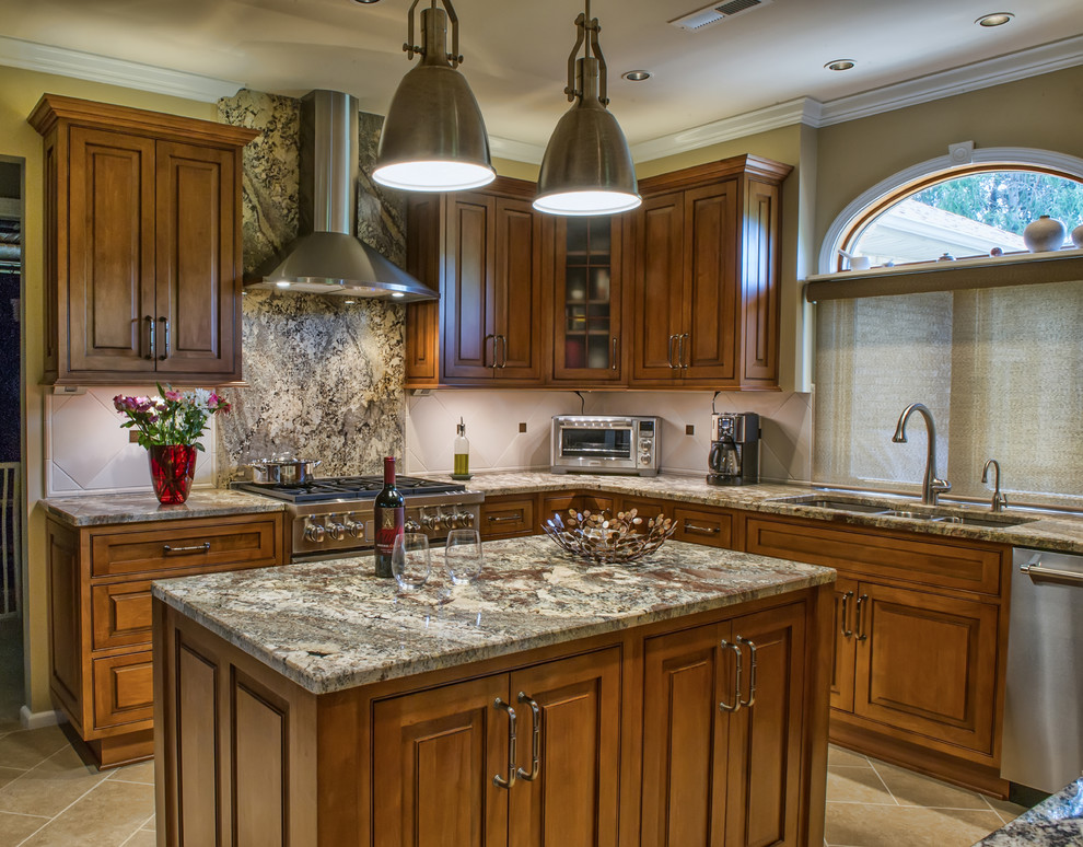 This is an example of a mid-sized traditional u-shaped eat-in kitchen in Charlotte with a triple-bowl sink, raised-panel cabinets, brown cabinets, granite benchtops, beige splashback, ceramic splashback, stainless steel appliances, ceramic floors and with island.