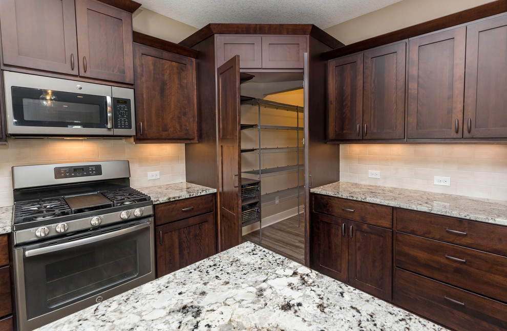 Inspiration for a transitional u-shaped vinyl floor and gray floor eat-in kitchen remodel with an undermount sink, shaker cabinets, dark wood cabinets, granite countertops, beige backsplash, ceramic backsplash, stainless steel appliances, an island and beige countertops