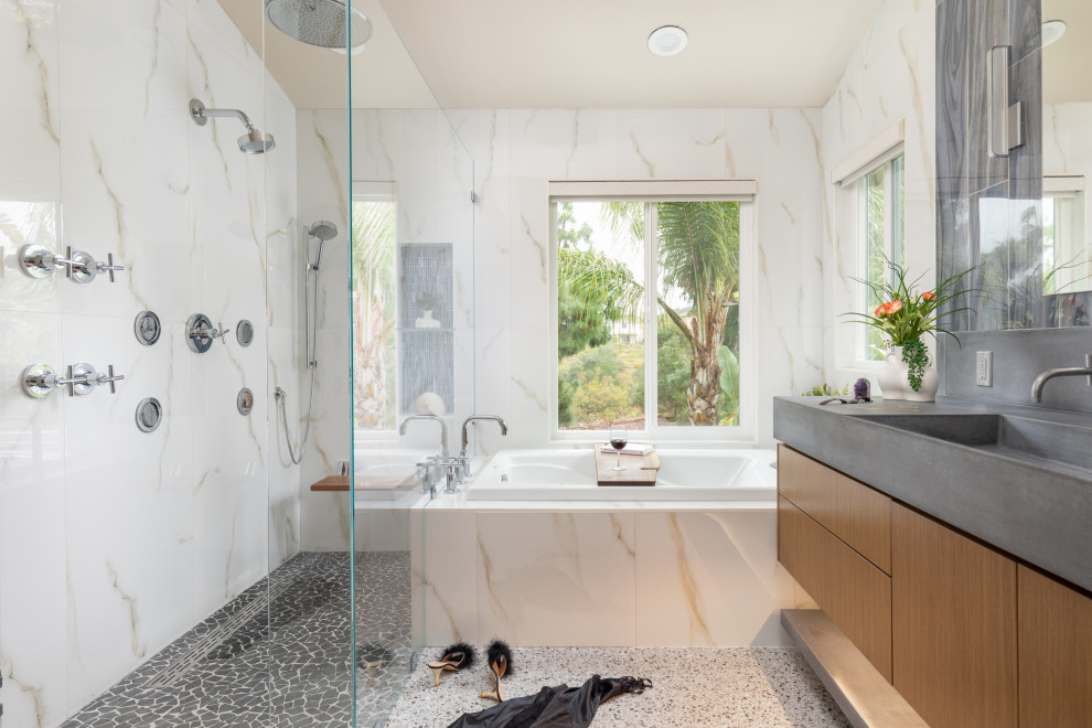Photo of a mid-sized modern master bathroom in San Diego with flat-panel cabinets, dark wood cabinets, a hot tub, a curbless shower, multi-coloured tile, porcelain tile, porcelain floors, a trough sink, concrete benchtops, white floor, a hinged shower door, grey benchtops, a shower seat, a single vanity, a floating vanity and vaulted.