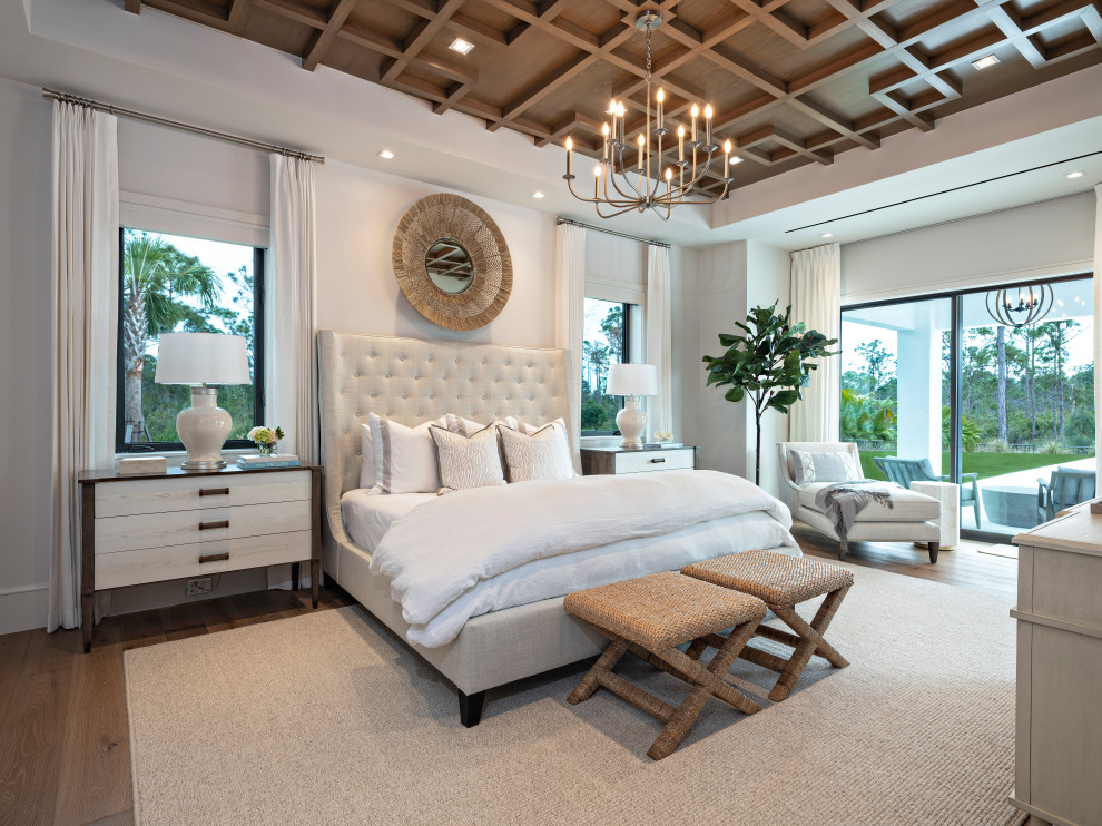 マイアミにある広いトランジショナルスタイルのおしゃれな主寝室 (白い壁、淡色無垢フローリング、茶色い床、表し梁) のレイアウト