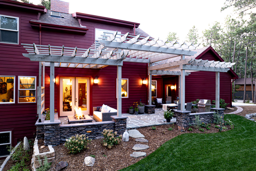 Cette image montre un porche d'entrée de maison arrière traditionnel de taille moyenne avec un foyer extérieur, des pavés en pierre naturelle et une pergola.