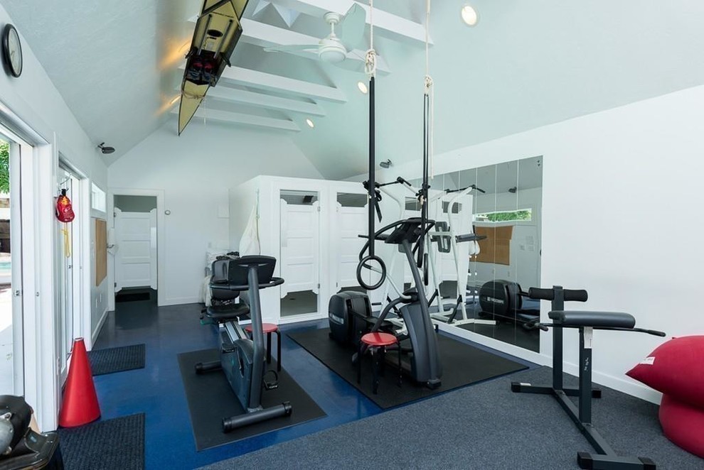 This is an example of a mid-sized contemporary home weight room in Philadelphia with white walls, cork floors and blue floor.