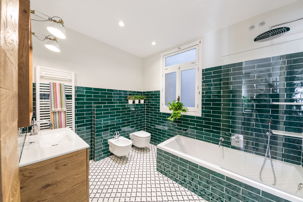 Photo of a mid-sized contemporary 3/4 bathroom in Alicante-Costa Blanca with flat-panel cabinets, medium wood cabinets, a shower/bathtub combo, green tile, ceramic tile, wood benchtops, a drop-in tub, a two-piece toilet, green walls, terra-cotta floors, a wall-mount sink, grey floor and an open shower.