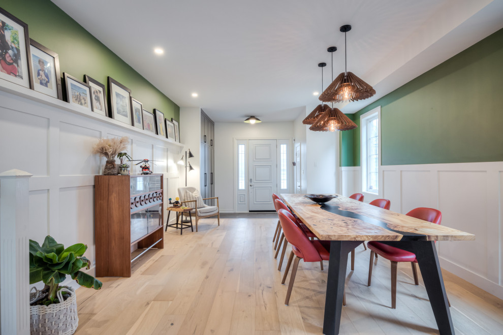 Esempio di una sala da pranzo aperta verso la cucina scandinava con pareti verdi, parquet chiaro, camino classico, cornice del camino in legno, pavimento beige e boiserie