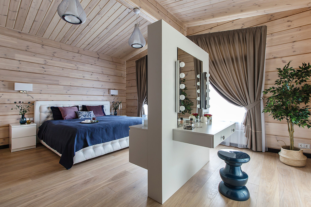 This is an example of a contemporary master bedroom in Moscow with light hardwood floors, beige floor and beige walls.