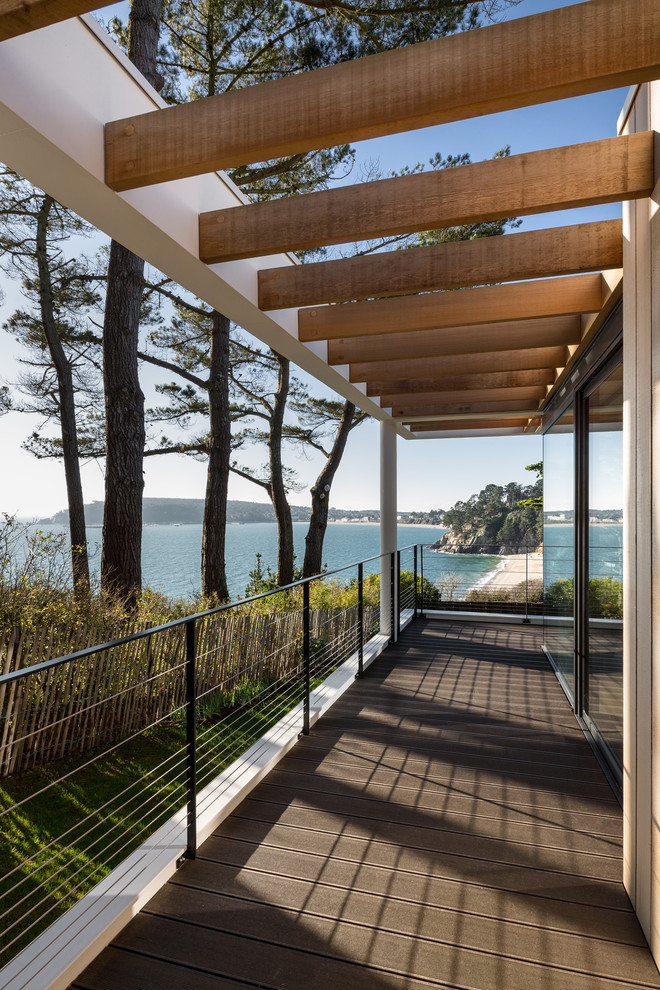 Design ideas for a contemporary side yard deck in Brest with a pergola.
