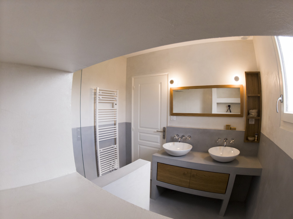 Inredning av ett medelhavsstil mellanstort grå grått badrum med dusch, med luckor med profilerade fronter, skåp i mellenmörkt trä, en kantlös dusch, grå väggar, betonggolv, ett fristående handfat, bänkskiva i betong och grått golv