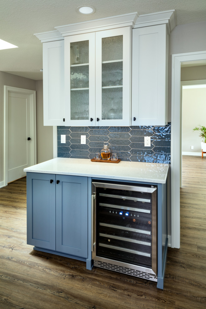 Photo of a large modern kitchen in Other with an undermount sink, shaker cabinets, blue cabinets, quartz benchtops, grey splashback, glass tile splashback, stainless steel appliances, with island, brown floor and white benchtop.