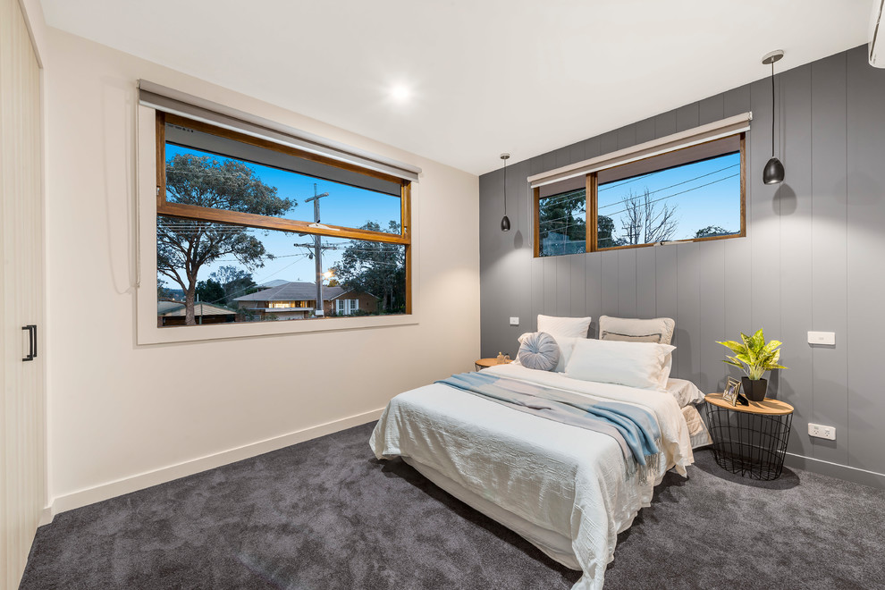 This is an example of a scandinavian master bedroom in Melbourne with beige walls, carpet and grey floor.