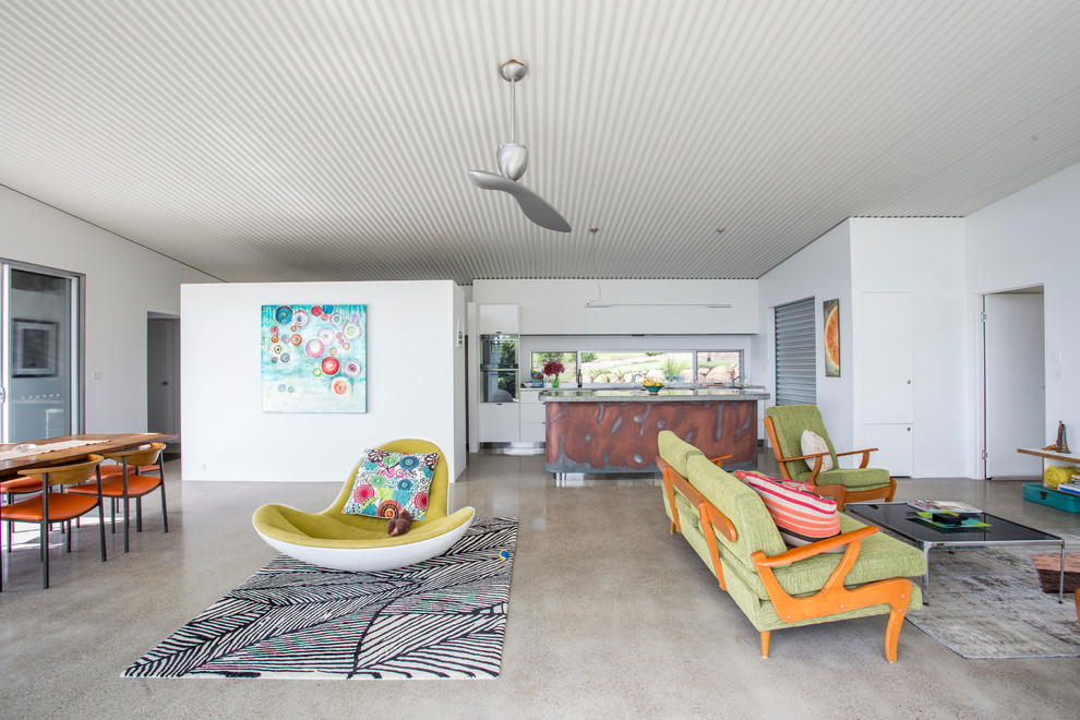 This is an example of an expansive country open plan dining in Sydney with grey walls, concrete floors and no fireplace.