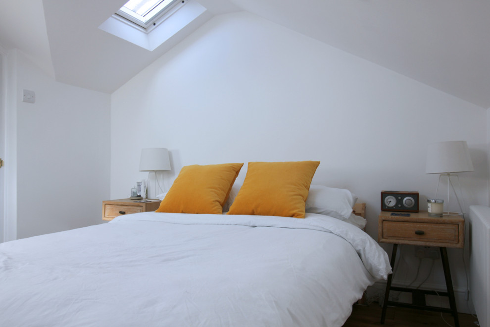 Design ideas for a small contemporary guest bedroom in London with white walls and light hardwood flooring.