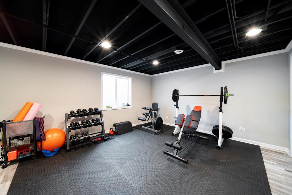 Design ideas for a contemporary multipurpose gym in Chicago with beige walls, vinyl floors and exposed beam.