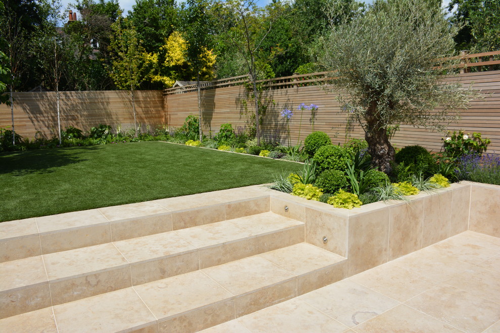 Photo of a medium sized contemporary back full sun garden for summer in London with natural stone paving.