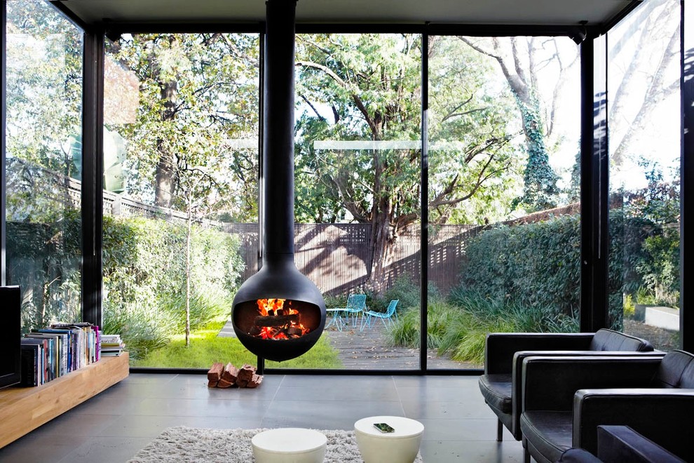 Contemporary open concept family room in Melbourne with ceramic floors and a hanging fireplace.