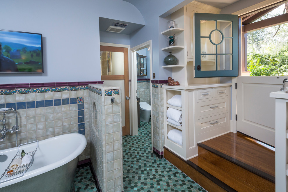 This is an example of a beach style master bathroom in Los Angeles with recessed-panel cabinets, white cabinets, a freestanding tub, a one-piece toilet, blue tile, ceramic tile, blue walls, mosaic tile floors, an undermount sink and zinc benchtops.