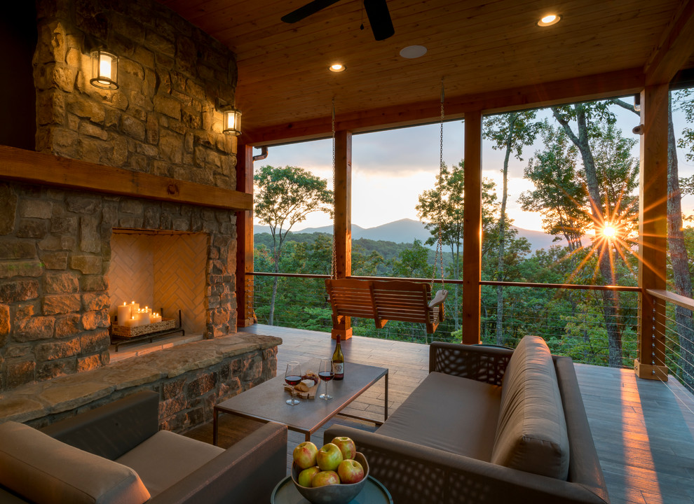 Arts and crafts deck photo with a roof extension and a fireplace