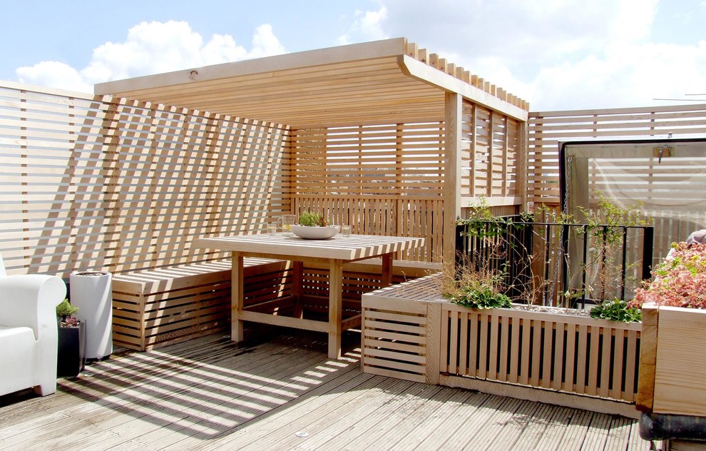 Design ideas for a contemporary deck in London with a pergola.