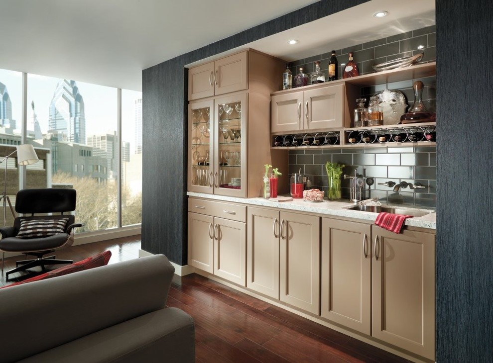 Photo of a mid-sized transitional single-wall seated home bar in Denver with an undermount sink, shaker cabinets, beige cabinets, quartz benchtops, grey splashback, subway tile splashback, dark hardwood floors and brown floor.