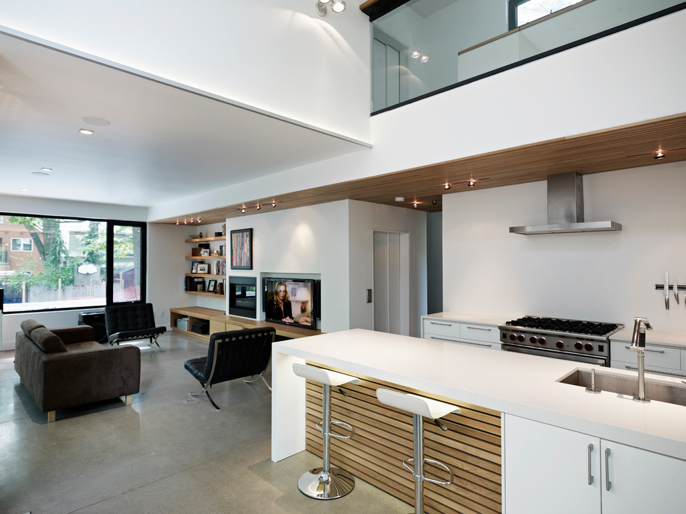 Photo of a contemporary galley open plan kitchen in Toronto with flat-panel cabinets, white cabinets, white splashback, stainless steel appliances, an undermount sink and with island.