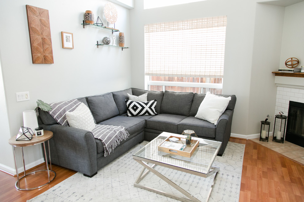 Living room - mid-sized scandinavian formal and open concept medium tone wood floor and brown floor living room idea in Los Angeles with gray walls, no tv, a corner fireplace and a brick fireplace