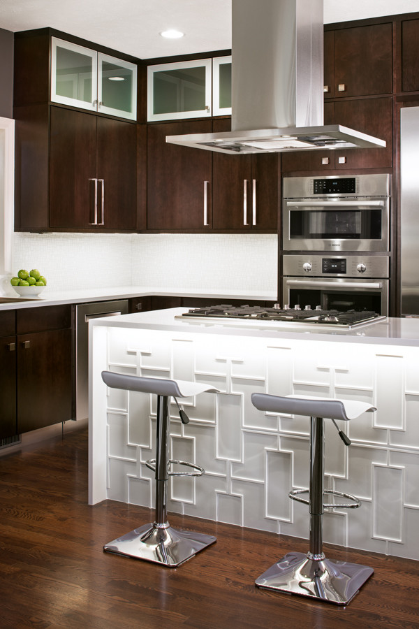 Example of a mid-sized trendy u-shaped dark wood floor eat-in kitchen design in Omaha with an undermount sink, flat-panel cabinets, dark wood cabinets, quartz countertops, white backsplash, glass tile backsplash, stainless steel appliances and an island