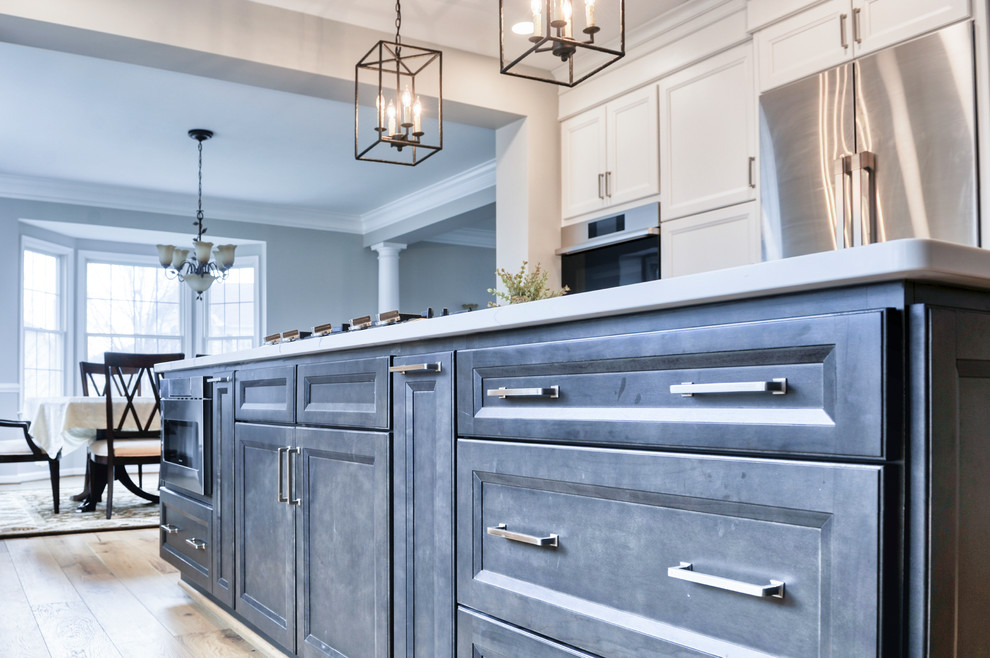 Huge transitional galley light wood floor and brown floor eat-in kitchen photo in DC Metro with an undermount sink, beaded inset cabinets, white cabinets, quartzite countertops, white backsplash, marble backsplash, stainless steel appliances, an island and white countertops