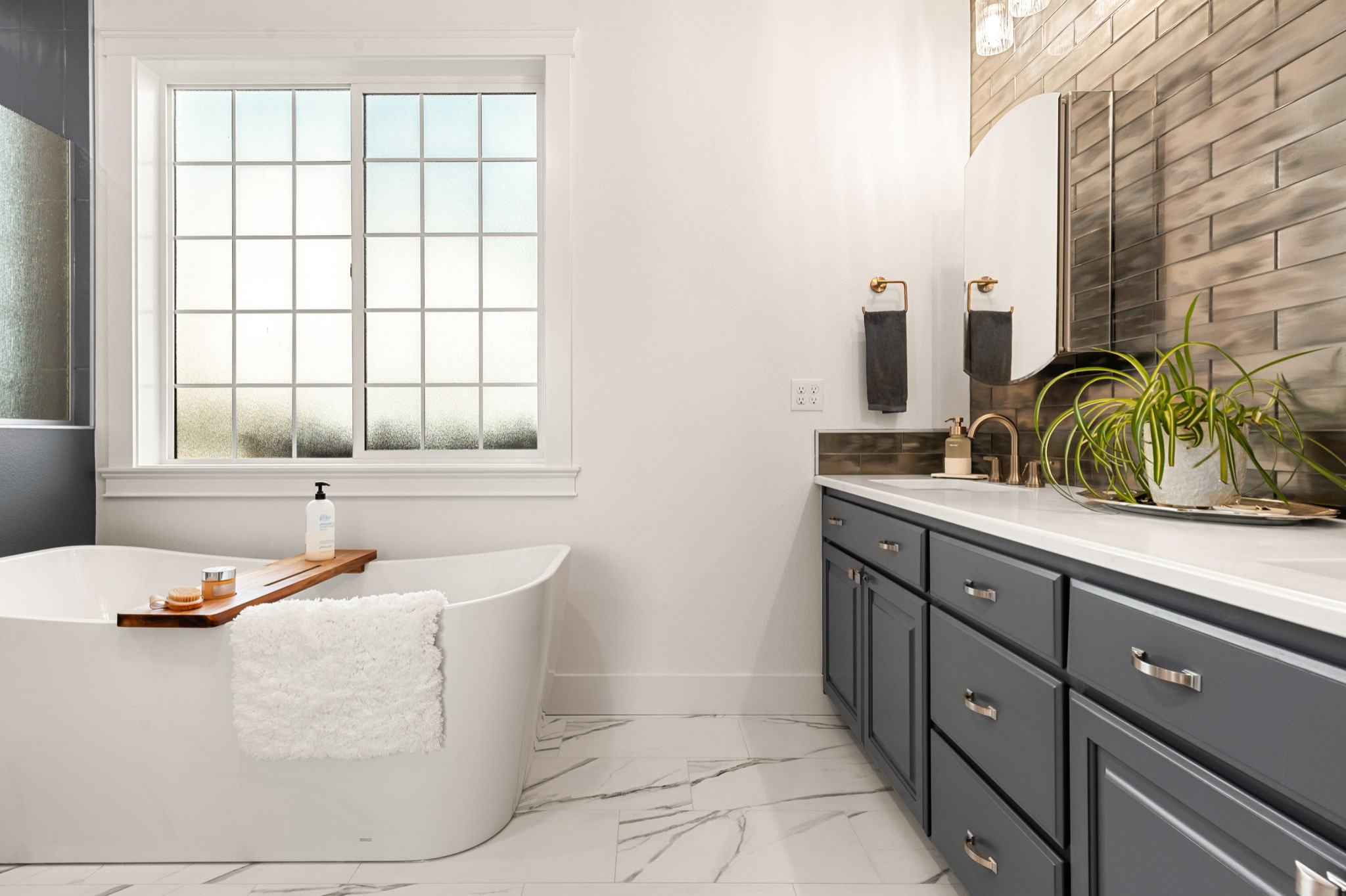 Bathroom vanity faucets with a glass tile backsplash.
