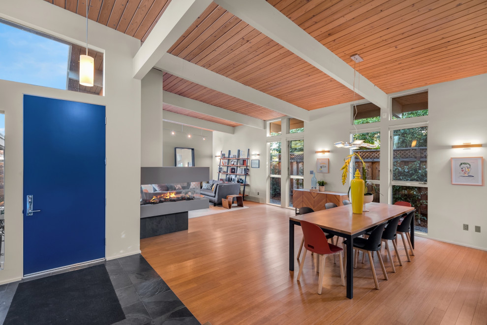 Midcentury entryway in Other with bamboo floors, a blue front door and exposed beam.