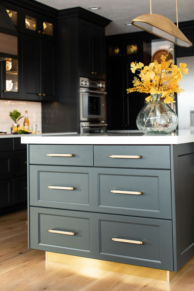 Large transitional medium tone wood floor kitchen photo in Seattle with an undermount sink, quartz countertops, white backsplash, subway tile backsplash, stainless steel appliances, an island and white countertops