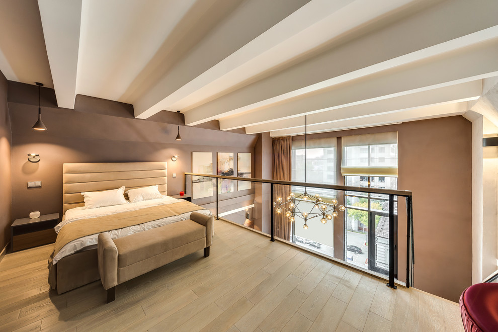 Contemporary loft-style bedroom in Moscow with light hardwood floors, beige floor and brown walls.