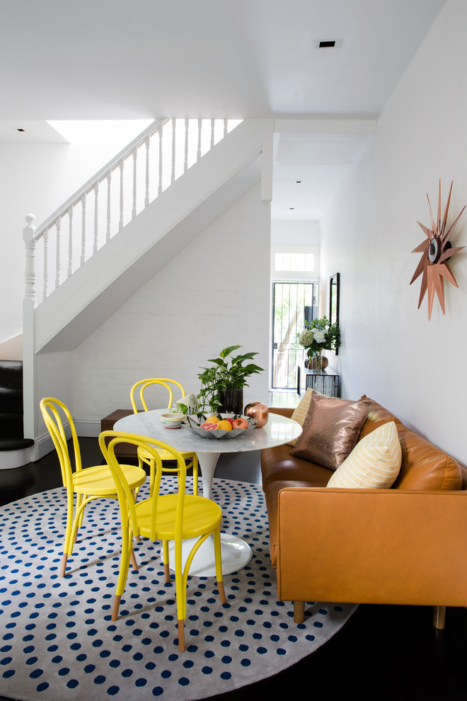 This is an example of an eclectic dining room in Sydney with white walls.