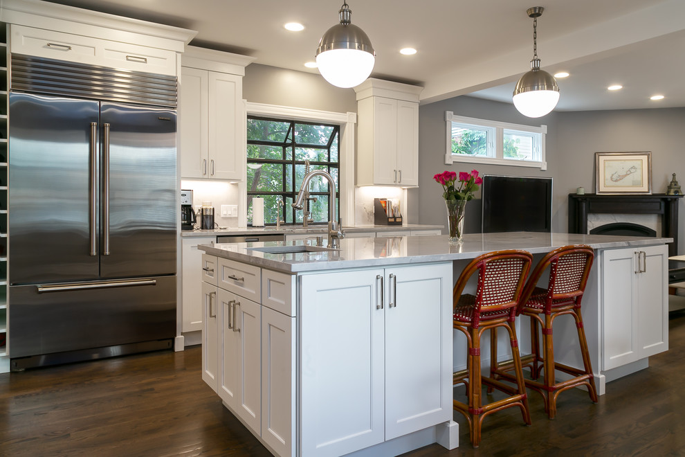 Inspiration for a large traditional l-shaped open plan kitchen in Chicago with shaker cabinets, white cabinets, granite benchtops, grey splashback, stone slab splashback, stainless steel appliances, with island and grey benchtop.