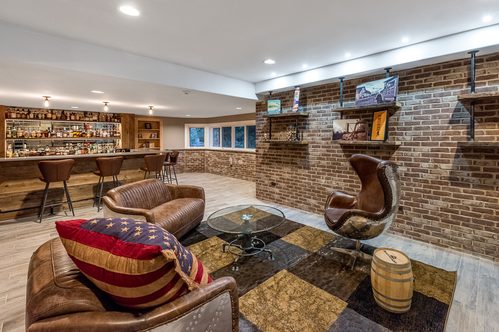 This is an example of a large country look-out basement in Chicago with grey walls, medium hardwood floors, no fireplace and brown floor.